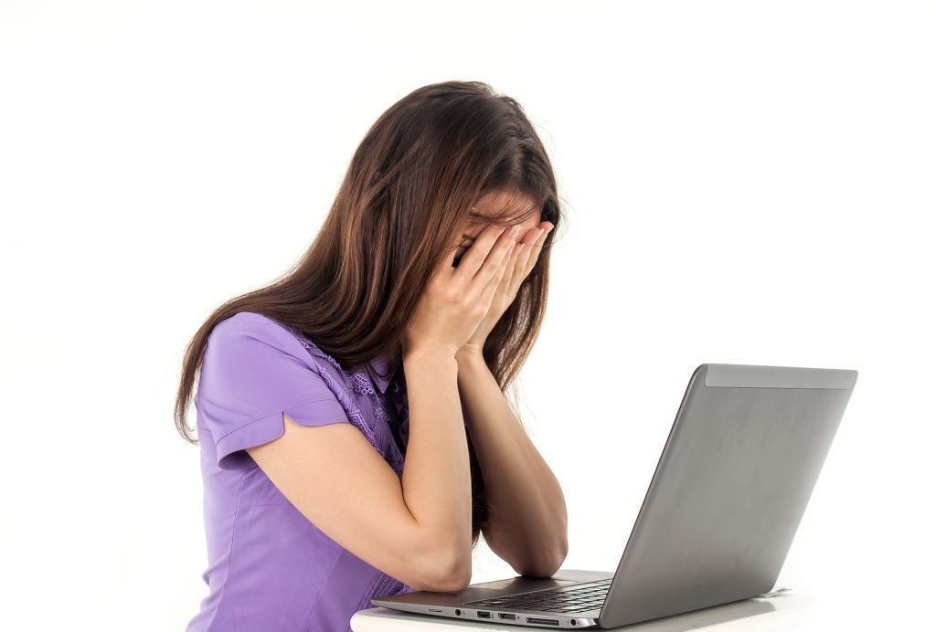 Девушка плачет над ноутбуком